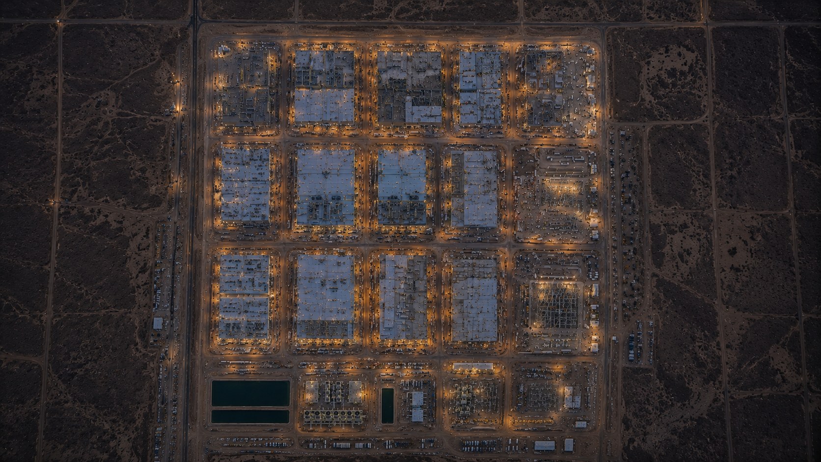 Aerial of a vast empty desert parcel beside an infrastructure corridor